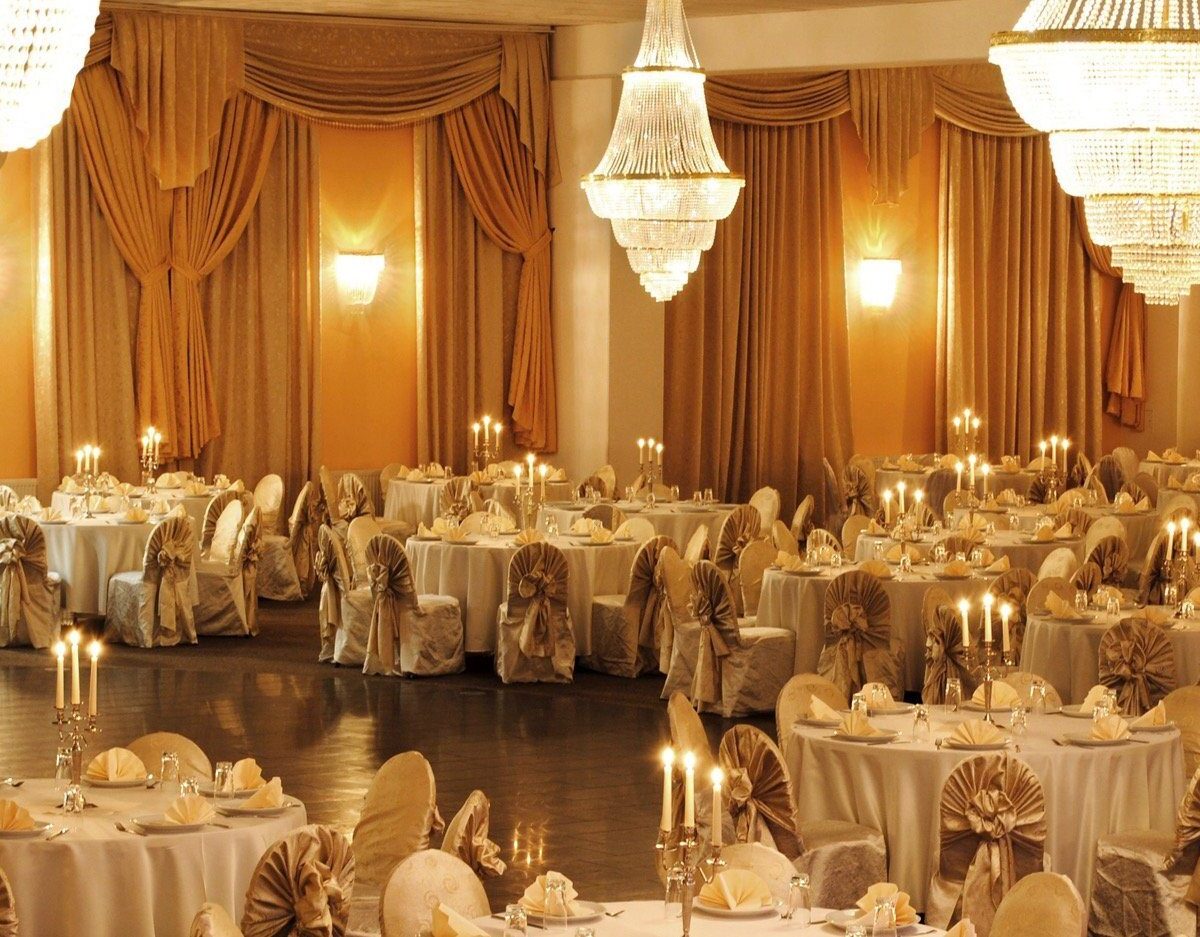 Ballsaal im Hotel Class mit Kronleuchtern, Vorhängen und festlich gedeckten Tischen