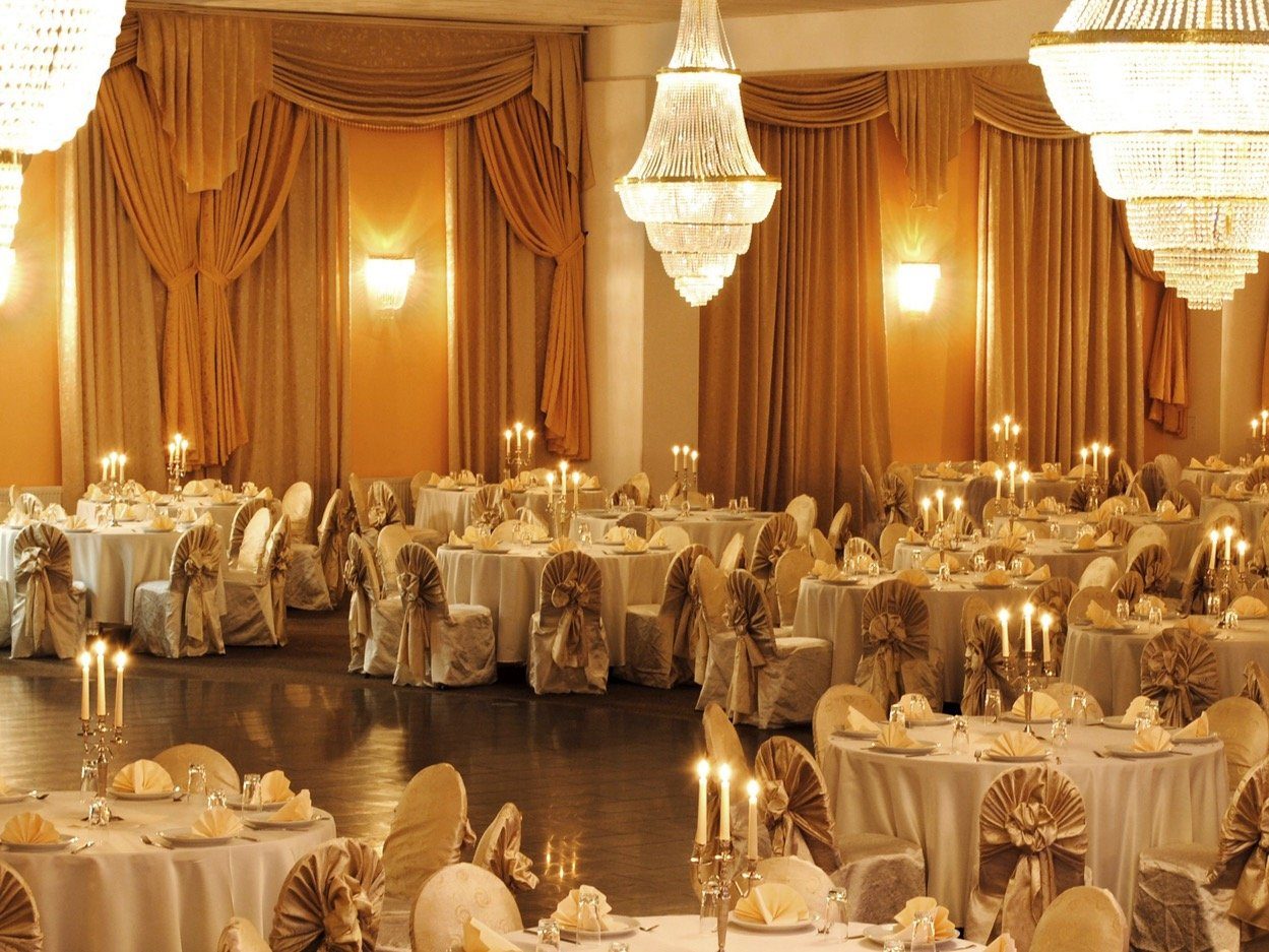 Ballsaal im Hotel Class mit Kronleuchtern, Vorhängen und festlich gedeckten Tischen