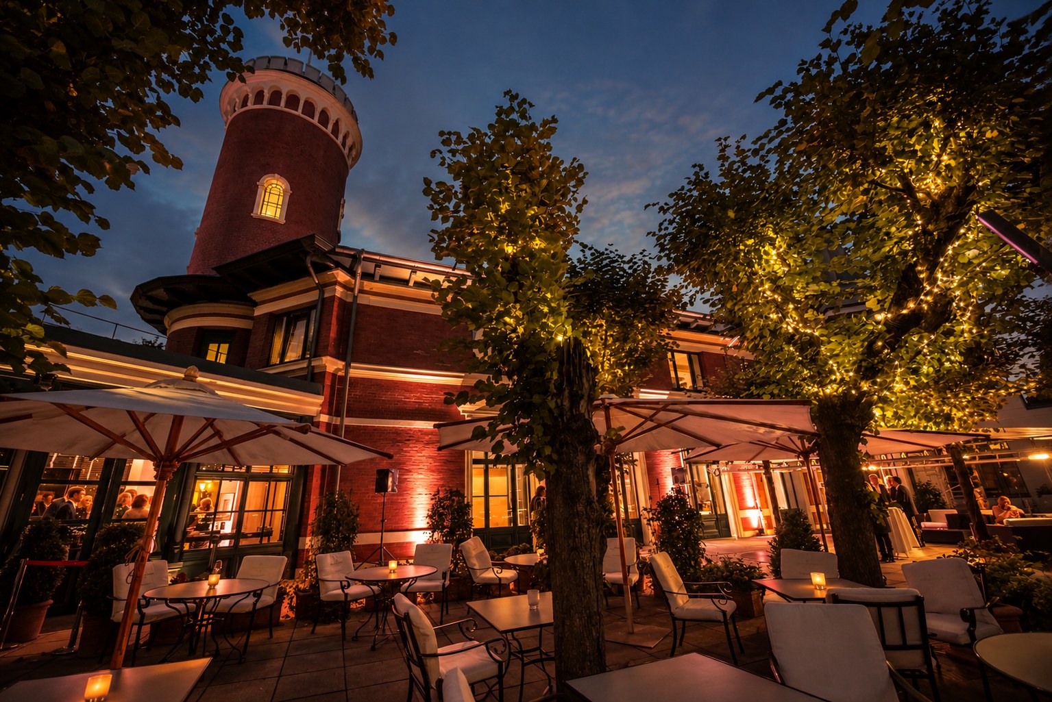 Der Süllberg in Hamburg-Blankenese am Abend, beleuchtete Terrasse unter alten Bäumen